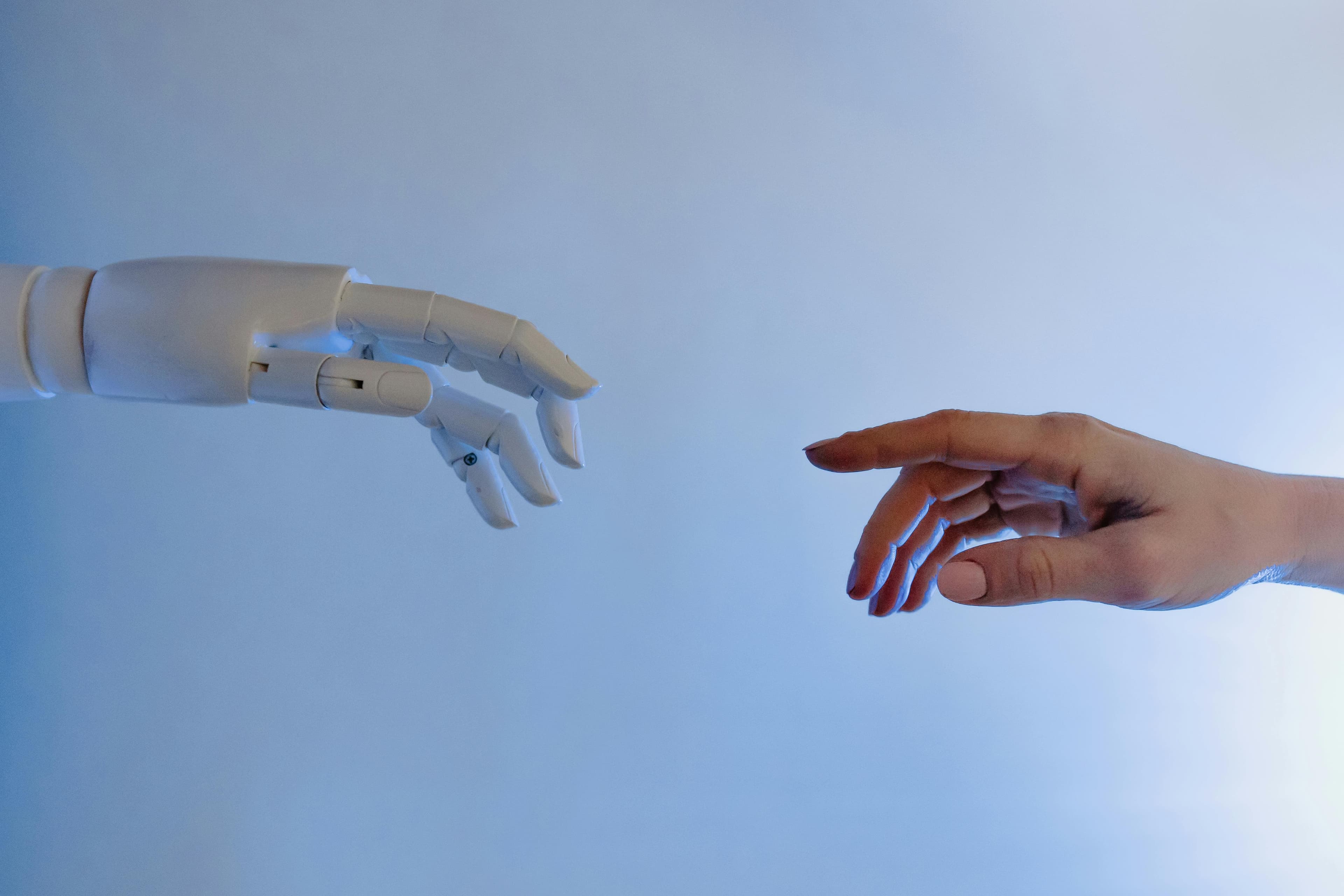 A robotic hand and a human hand reaching toward each other